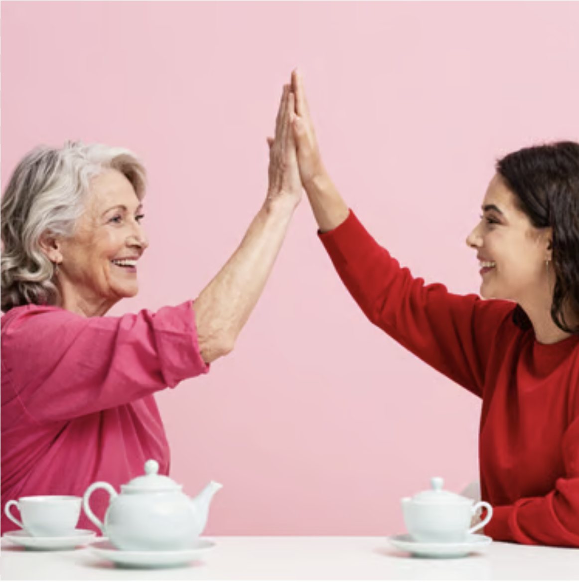 Two women meeting hands across a table